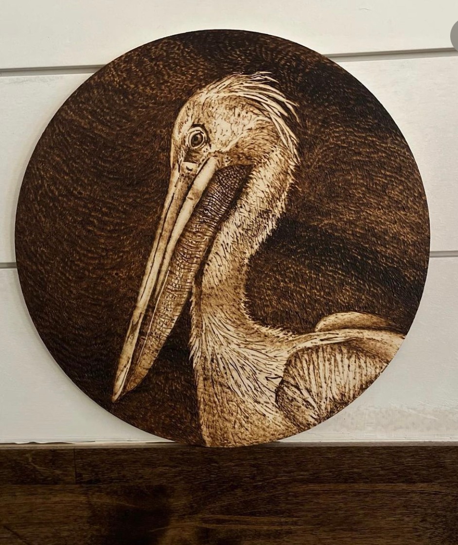 Detailed painting of a pelican with a long beak and textured feathers on a round canvas.