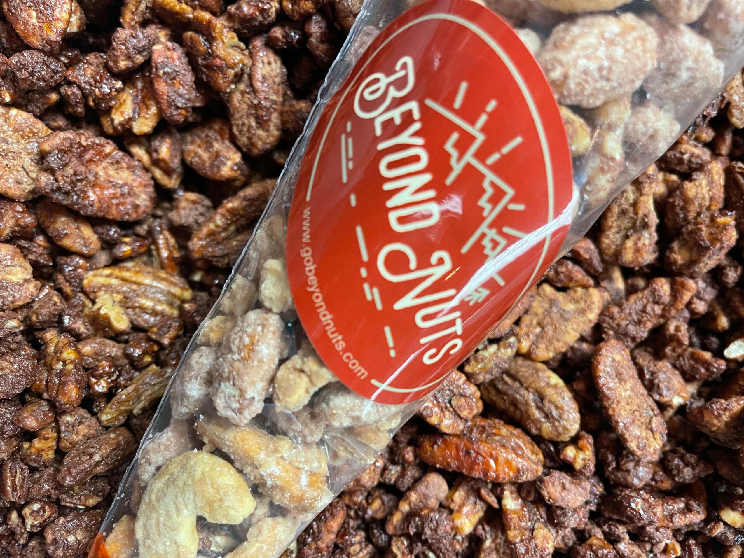 Clear plastic bag with a red circular label containing white text and graphics, placed on a bed of small brown rocks.