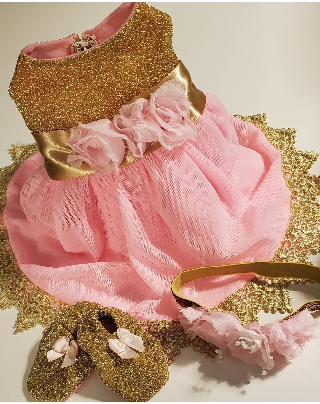 Pink dress with gold glitter, matching shoes, and a headband, all decorated with gold and pink accents.
