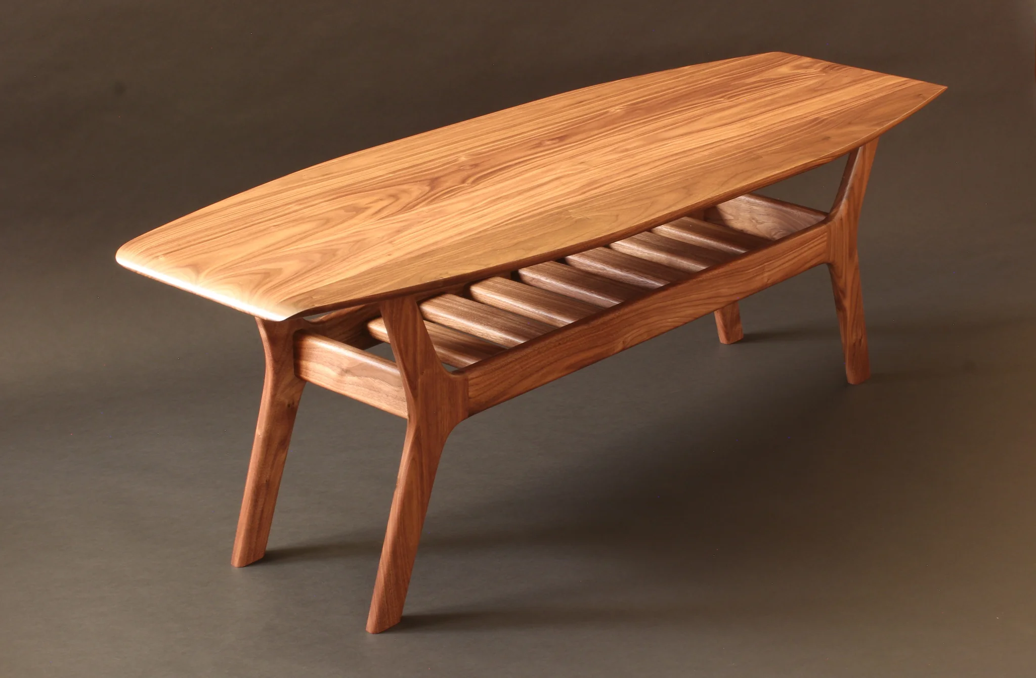 Wooden bench with slatted seat and angled legs, viewed from above, on a dark background.
