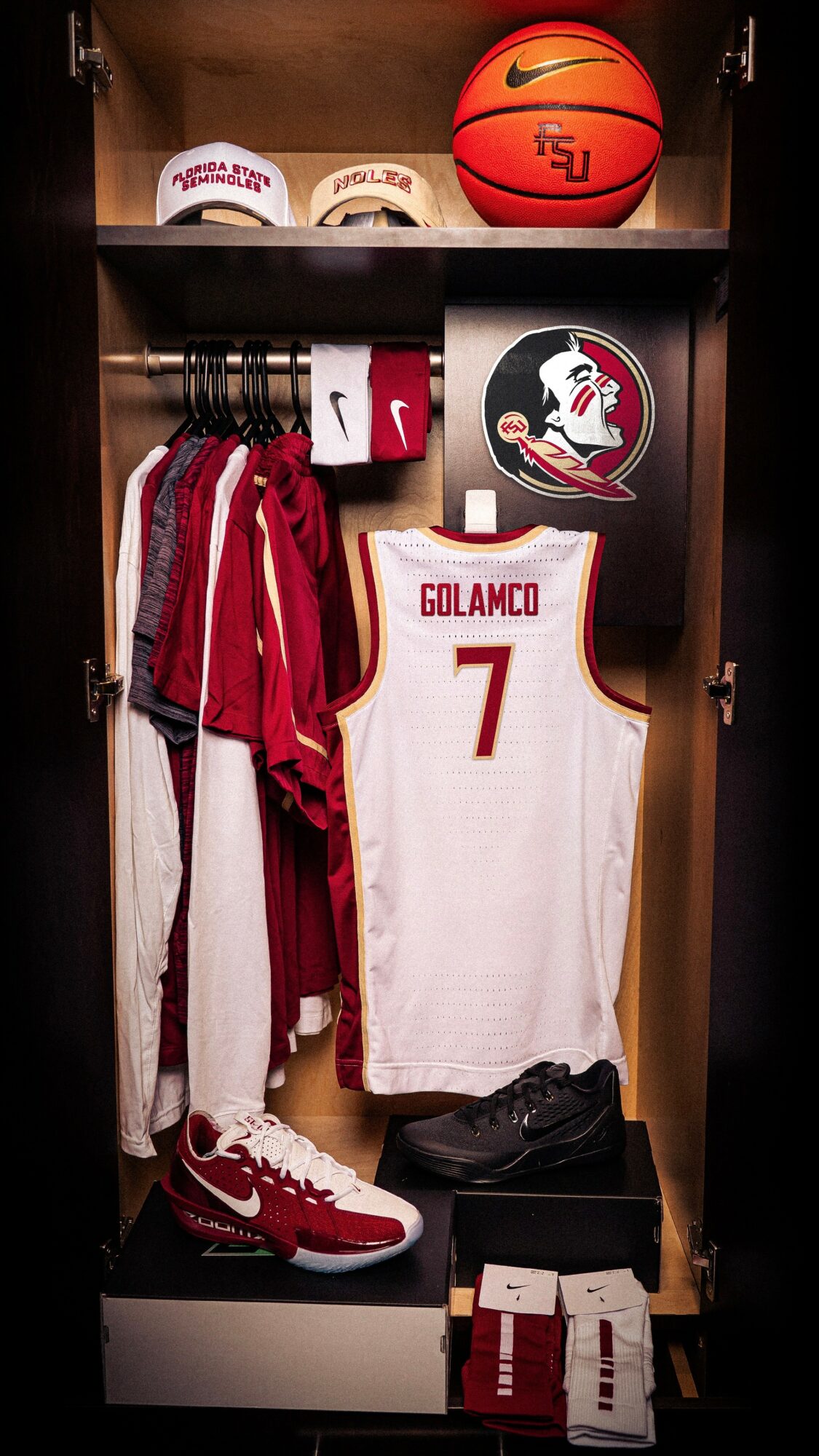 Basketball uniform, shoes, and gear in a locker, including a jersey with the name GOLAMCO and number 7, a basketball, and hats.