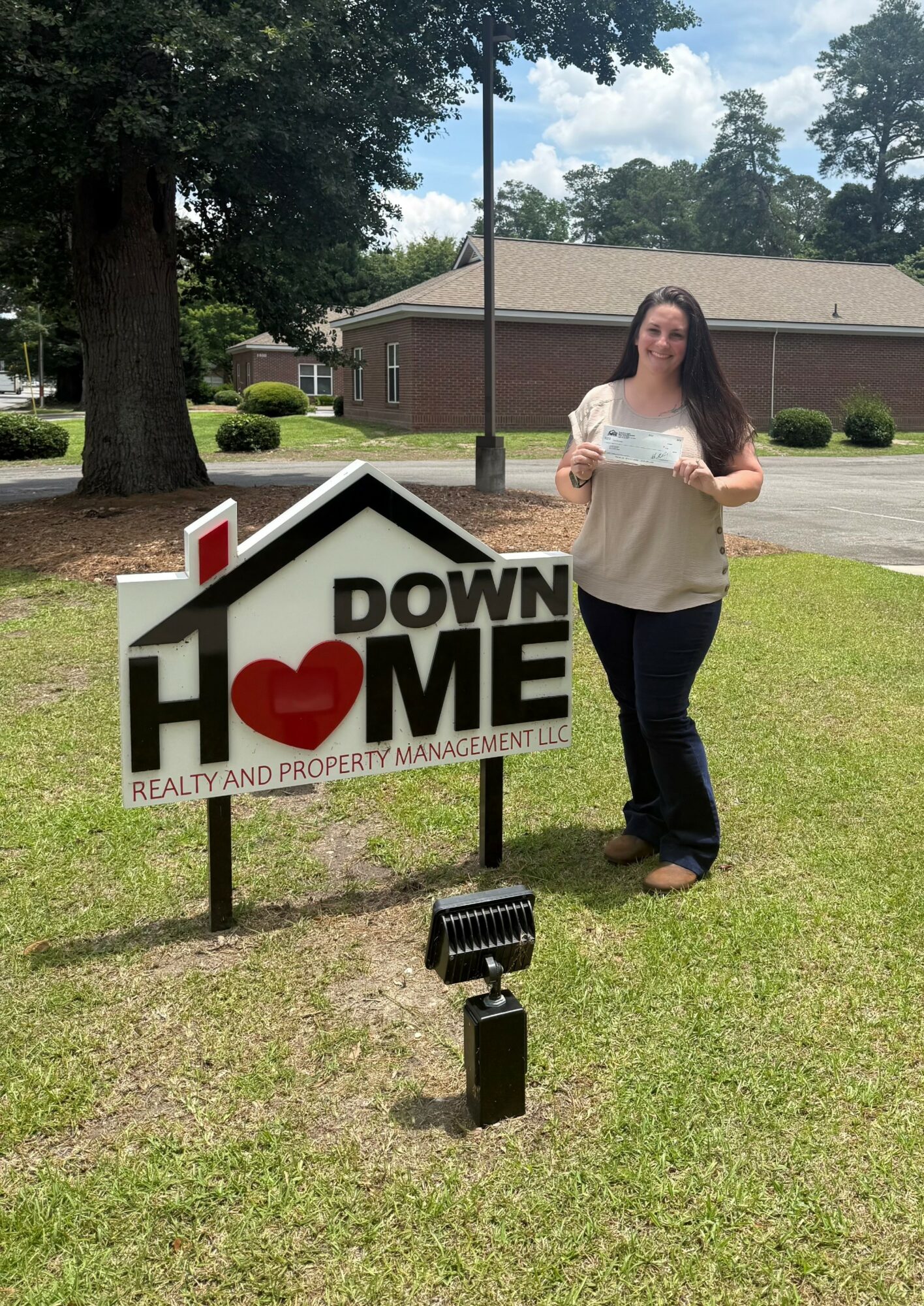 Woman standing next to a sign that says