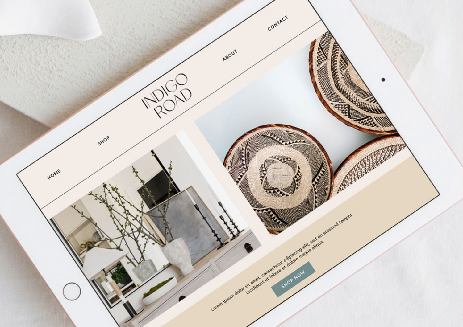 Tablet displaying a website with images of home decor and woven baskets, placed on a white surface.