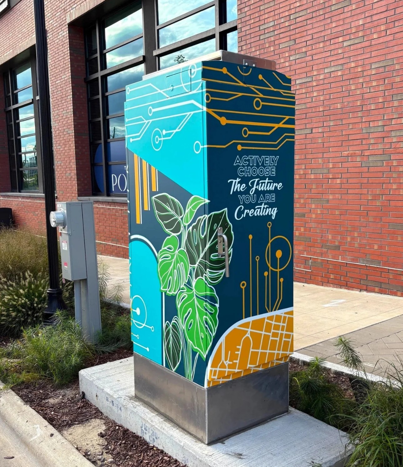 Colorful utility box with abstract designs and leaves, featuring the text 