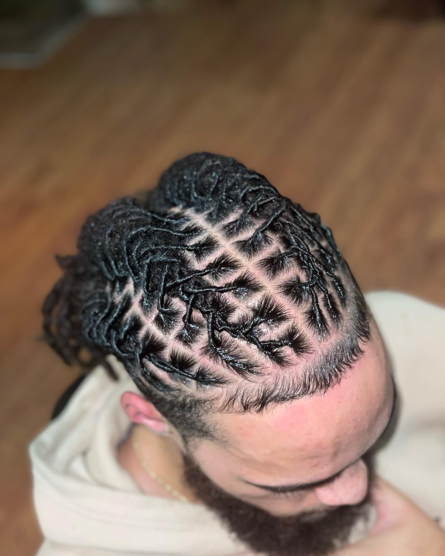 Top view of a person with neatly styled cornrows hairstyle, showing the scalp and hair pattern.