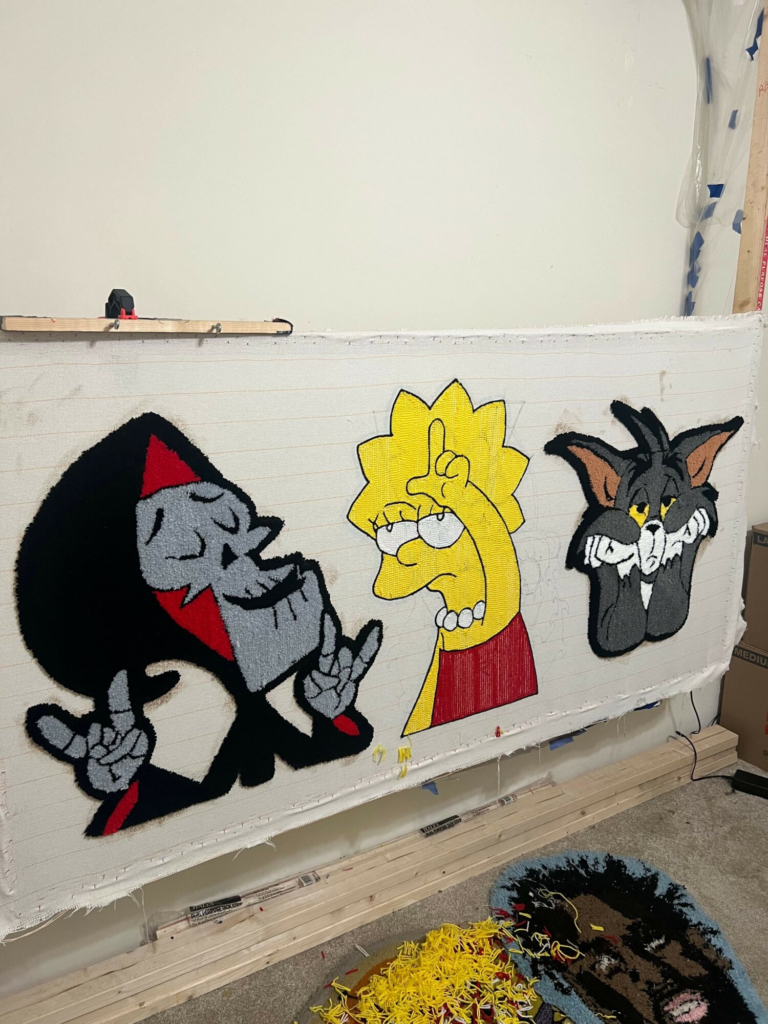 A colorful cartoon-style rug features characters from Tom and Jerry, including Tom, Jerry, and a yellow character, on a white background.
