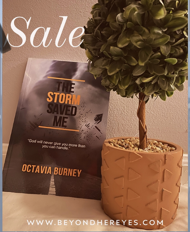 Book titled 'The Storm Saved Me' by Octavia Burney next to a potted plant with green leaves in a textured orange pot.