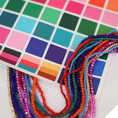 Color palette with various shades and a collection of colorful beaded necklaces on top.