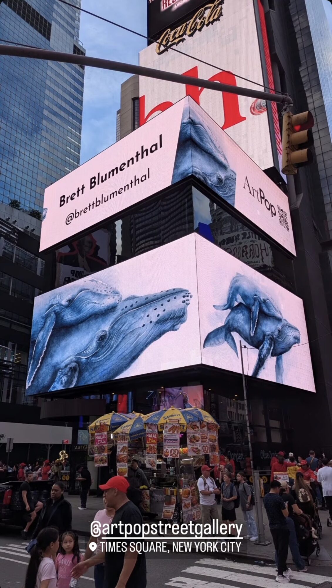 Billboard displays with blue whale images and a tweet from Brett Blumenthal, Times Square, New York City.