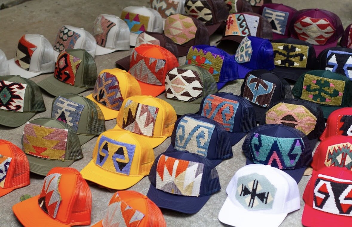 Collection of colorful, patterned caps arranged on a surface, featuring various geometric and abstract designs.