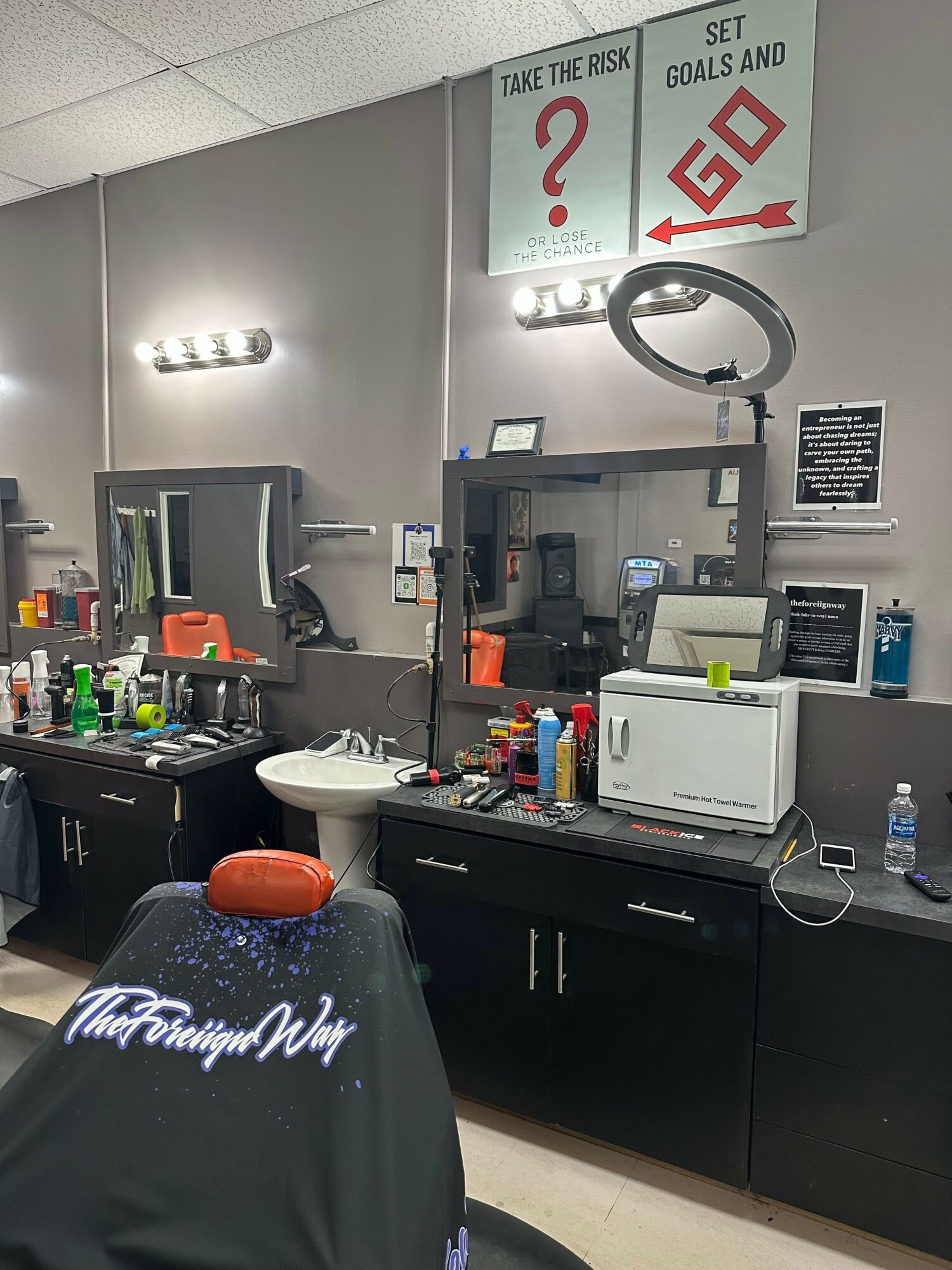 Laboratory workspace with equipment, computers, and a sign on the wall, viewed from the side. Word on the bottle is partially visible.