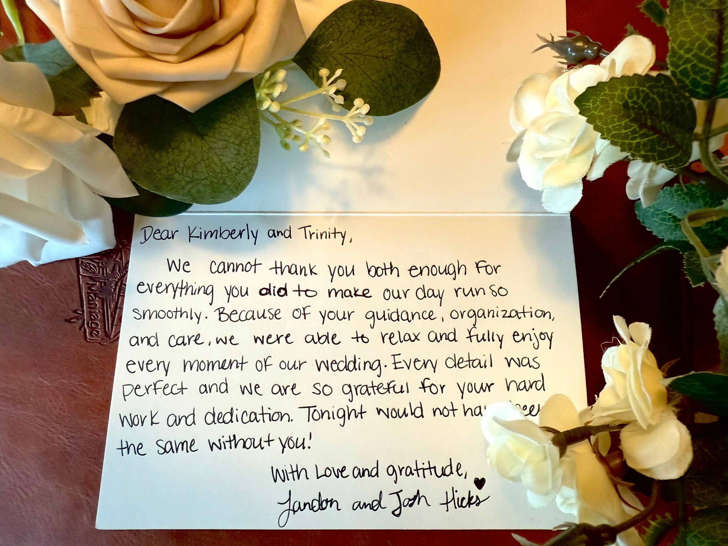 Handwritten note on paper surrounded by white flowers and green leaves, expressing gratitude and appreciation.