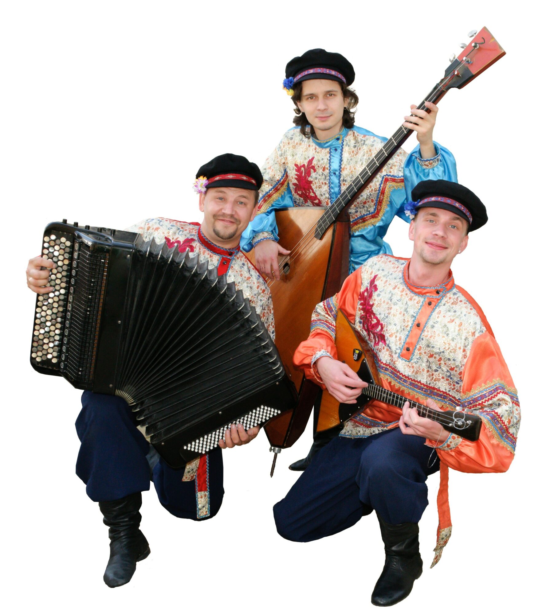 Three people in traditional clothing with musical instruments, one holding an accordion, one with a guitar, and one with a stringed instrument, smiling.