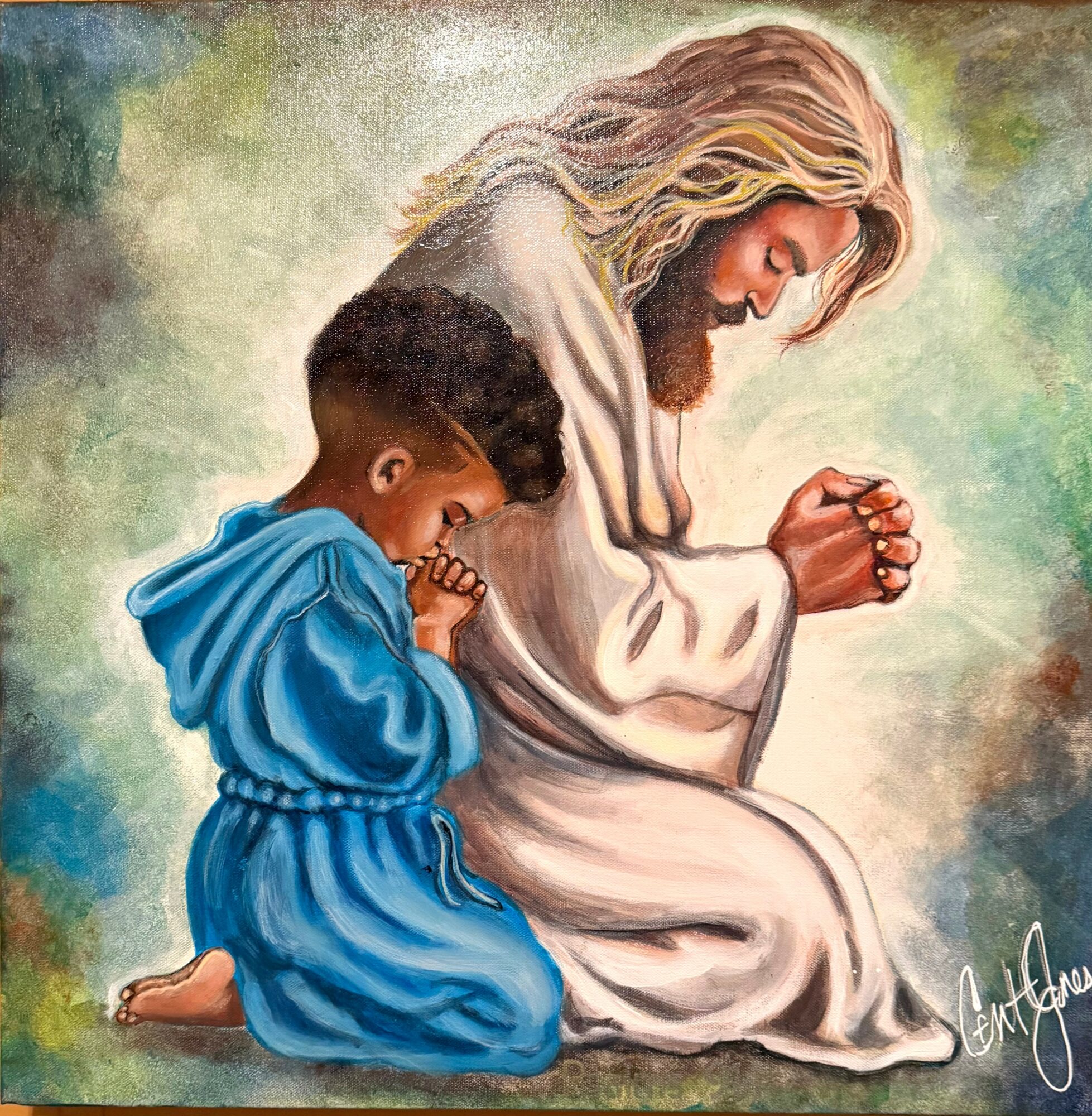 A man with long hair and beard kneels with a child in blue clothing, both praying with hands clasped, against a colorful background.