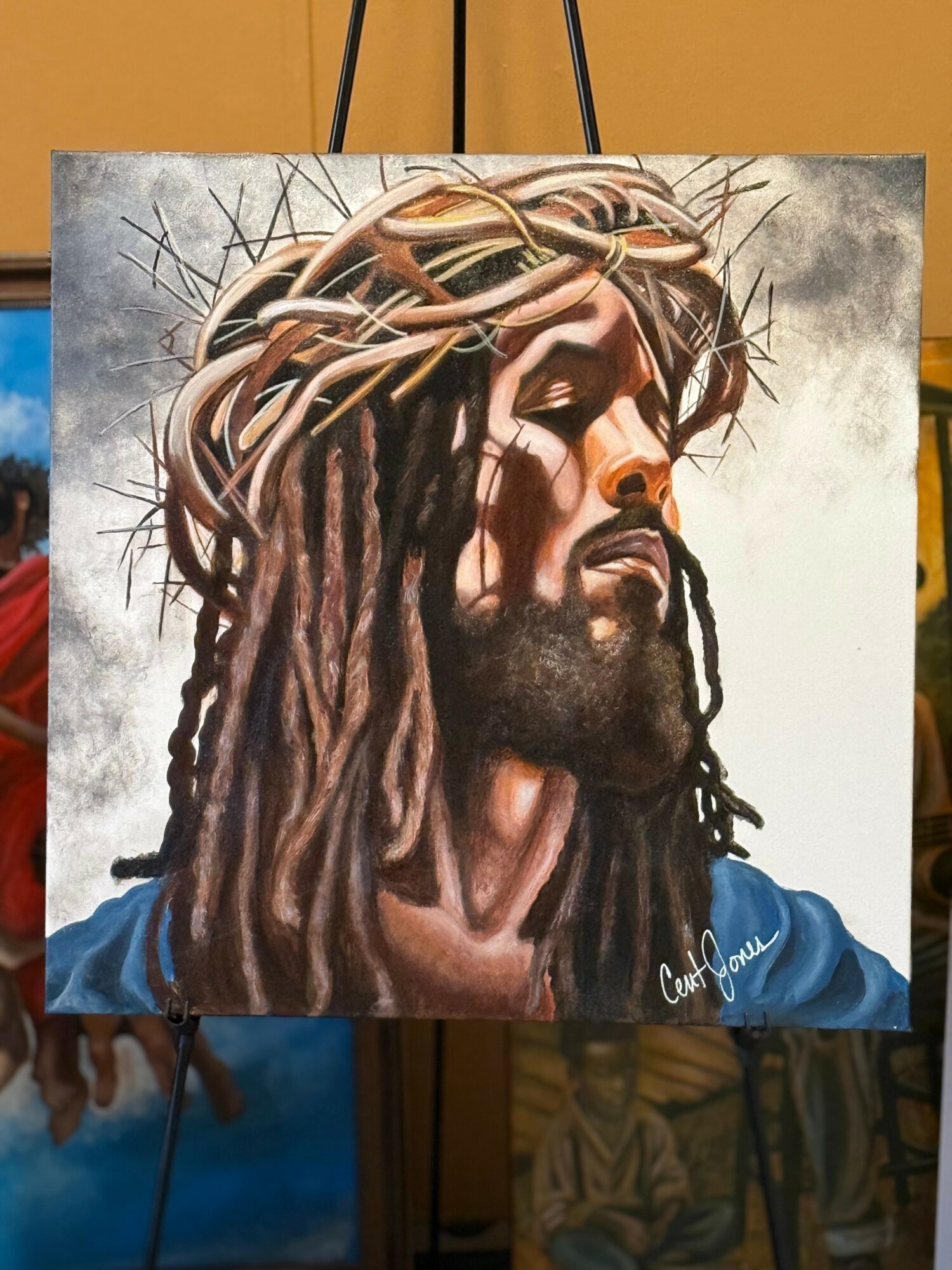 Painting of a man with long dreadlocks and a crown of thorns, wearing a blue garment, with a solemn expression.