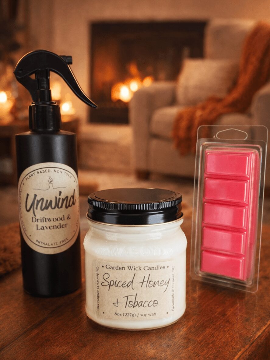 Black spray bottle labeled 'Unwind' with a fireplace and sofa in the background, on a wooden surface.