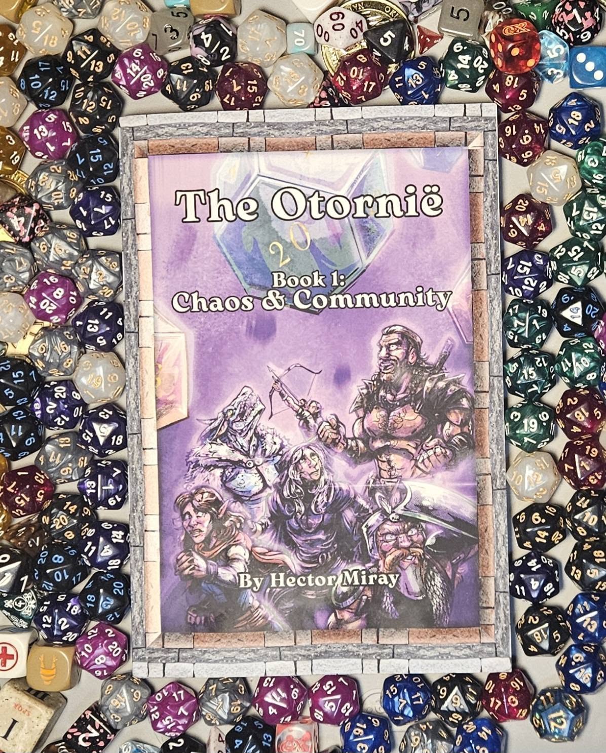 Book cover titled 'The Otorníe Book 1: Chaos & Community' by Hector Miray, surrounded by colorful dice.