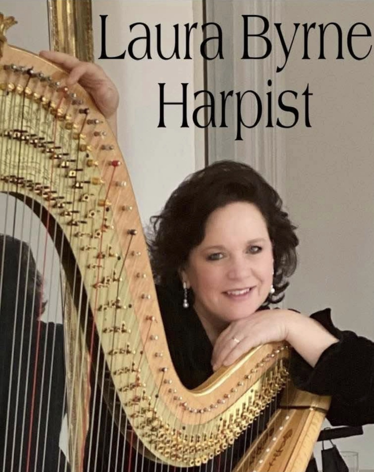 Laura Byrne Harpist smiling with a harp, resting her chin on her hand, in a portrait setting.