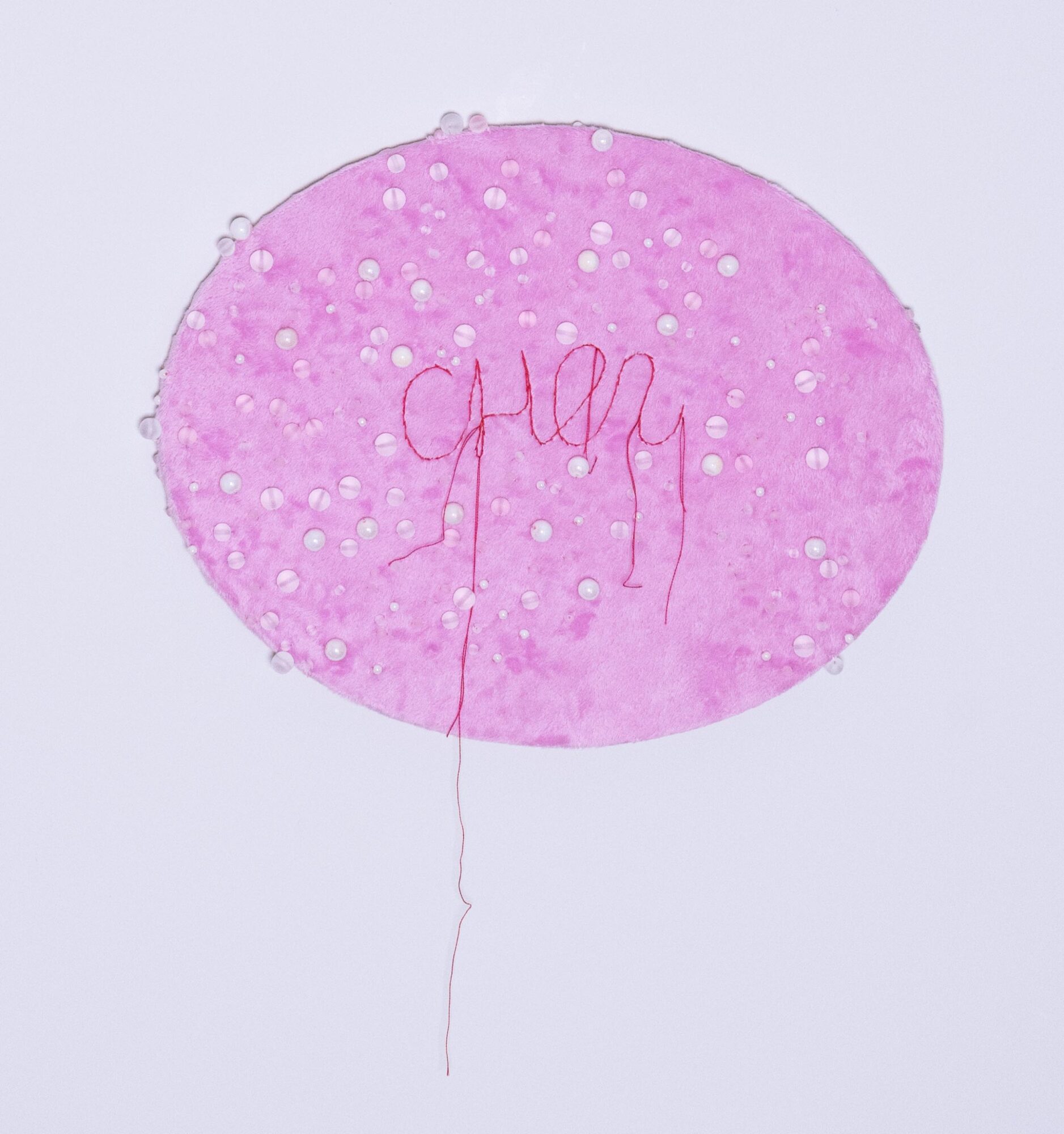 Pink oval balloon with white dots and red wire, with the word 'happy' written on it, on a light background.