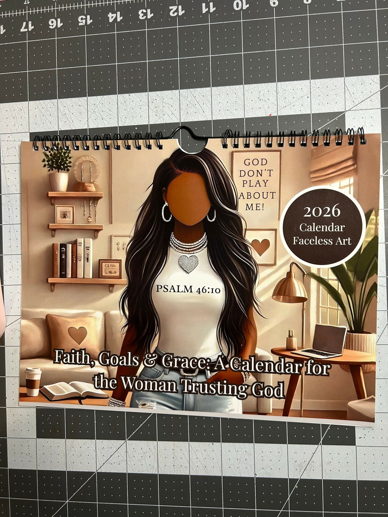 Calendar with a person with long hair, surrounded by home decor items, on a grid background.