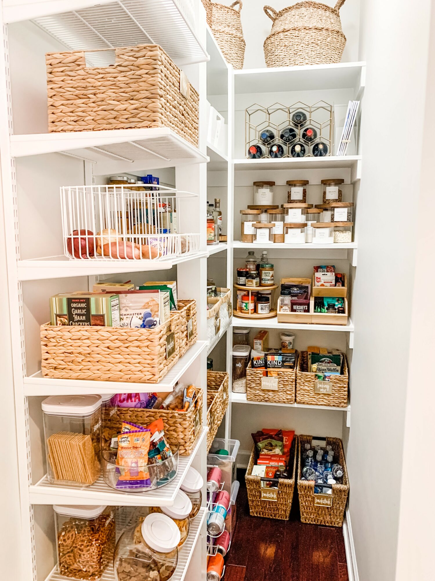 Closet with shelves containing baskets, jars, and various stored items, organized neatly in a bright space.