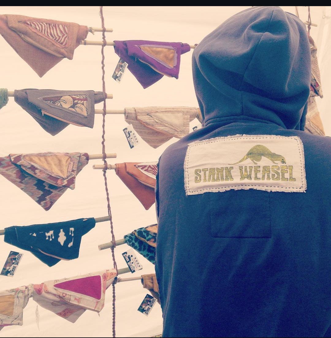 Person wearing a hoodie with a patch reading 'Star Wars' looks at colorful fabric flags hanging on a line.