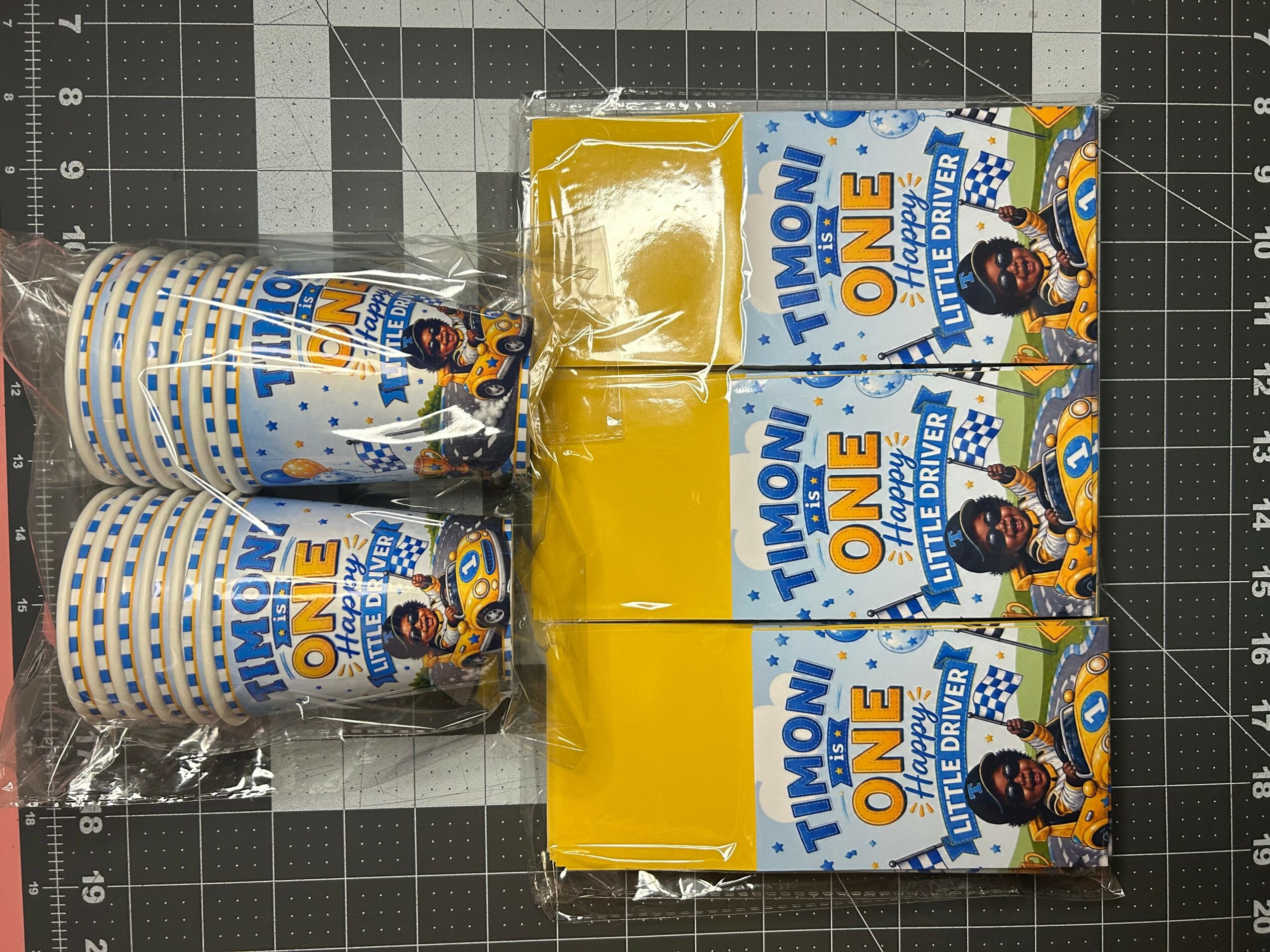 Stack of paper cups and two boxes of Timoni One chocolate bars on a cutting mat.