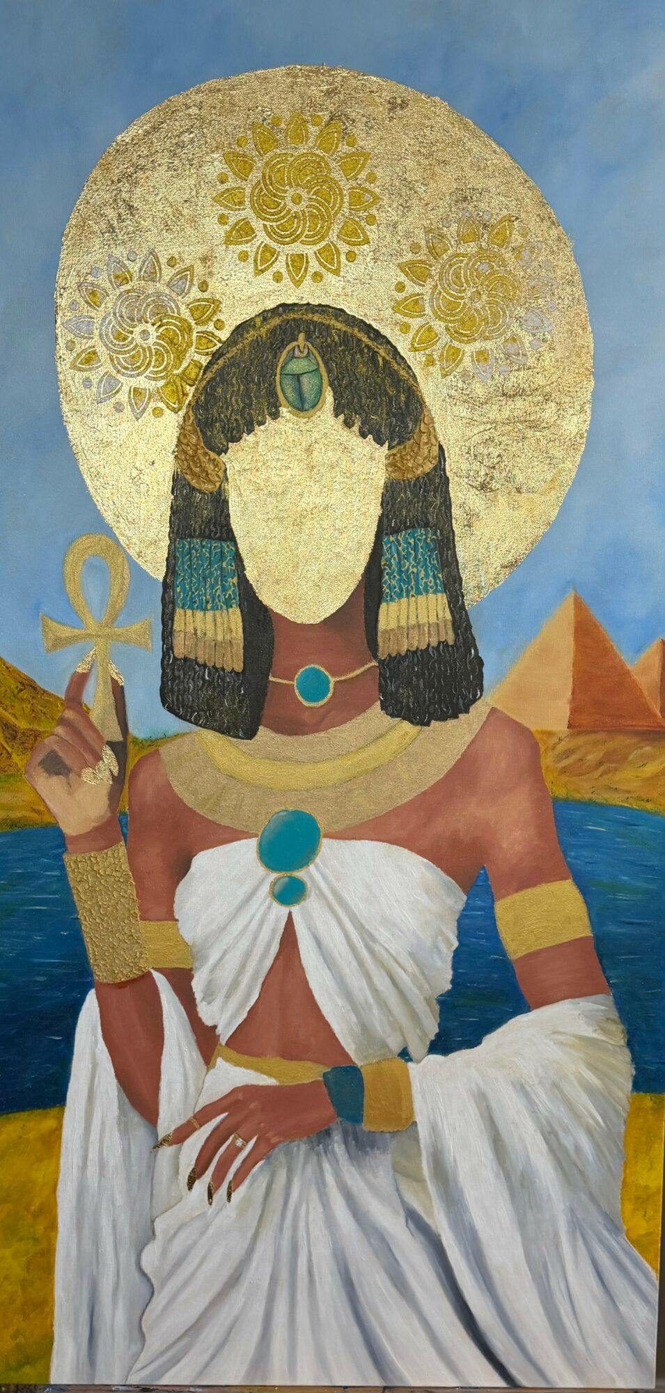 Portrait of a woman with Egyptian-style jewelry and attire, holding an ankh, with pyramids and water in background.