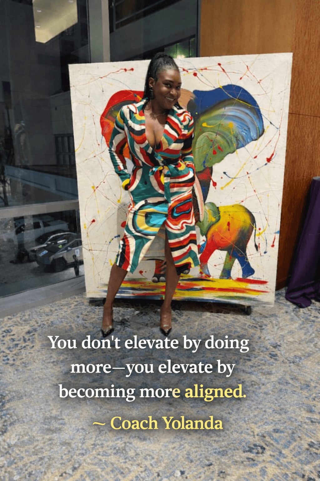 Woman standing in front of colorful abstract painting, wearing a multicolored dress, with a quote about elevation and alignment.