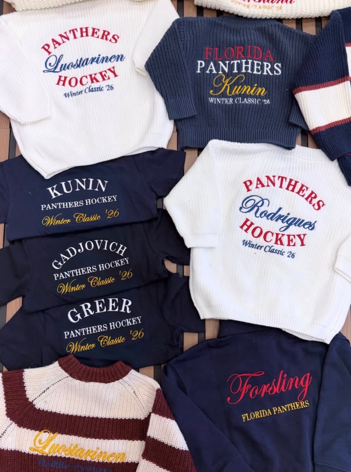Close-up of various sports team sweatshirts with team names and logos, including Panthers, Hockey, and Florida Panthers, in different colors.