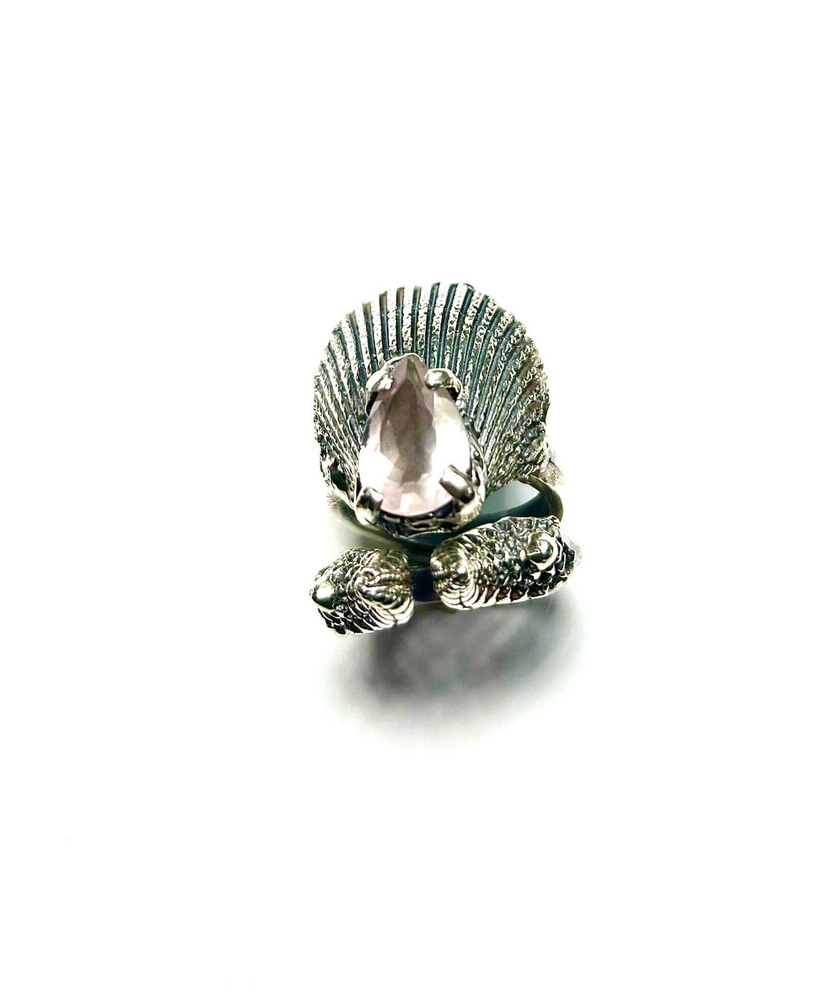 Ring with a large central gemstone and a fan-shaped decorative element behind it, set on a white background.