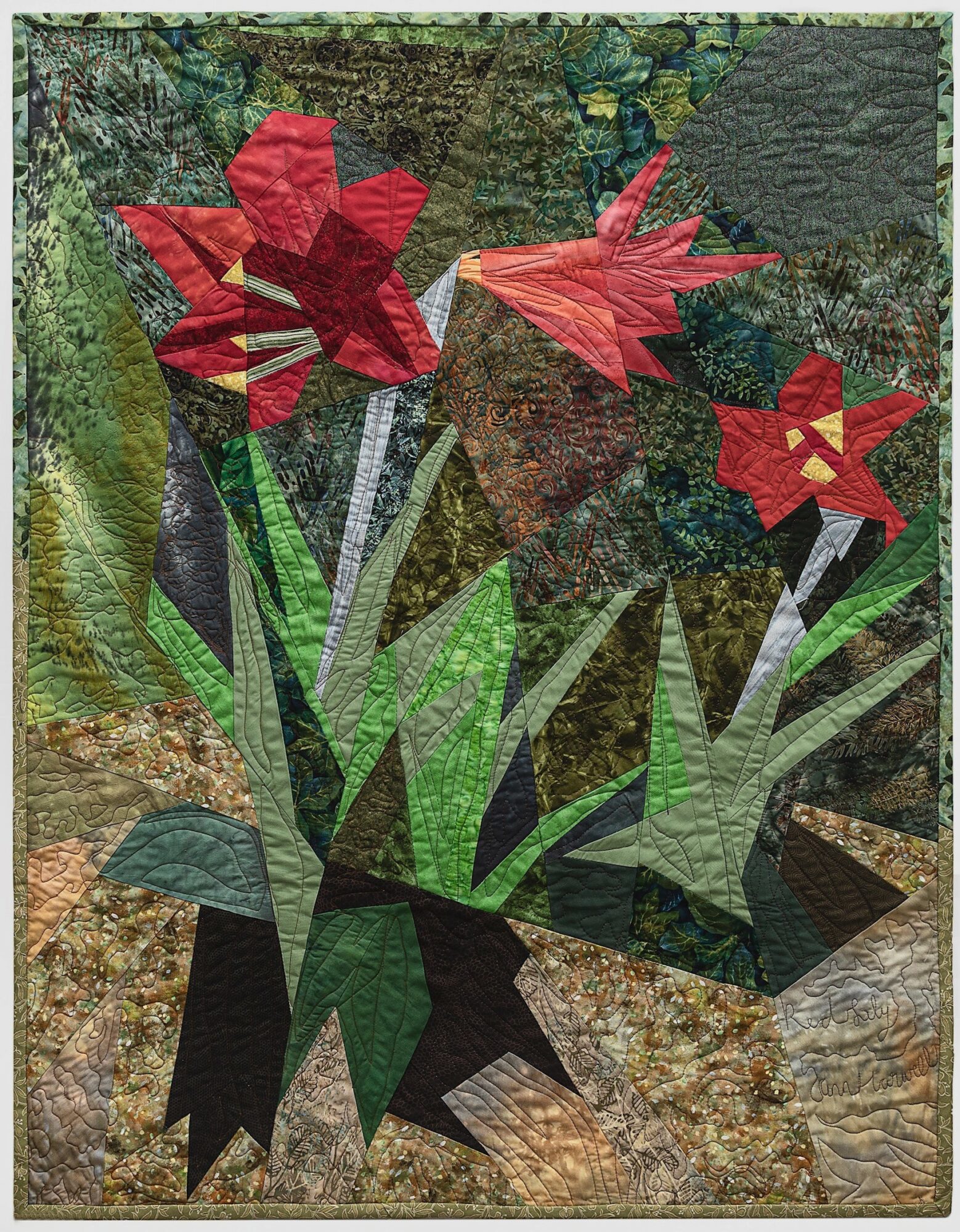 A quilt with red flowers, green leaves, and brown background fabric, arranged in a floral pattern.