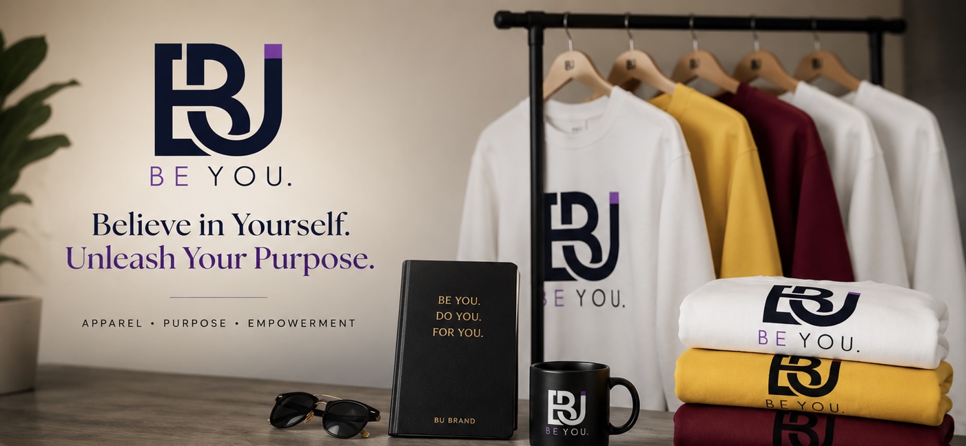Display of clothing and accessories with a logo and motivational text on a wall, including shirts, a mug, and a notebook.