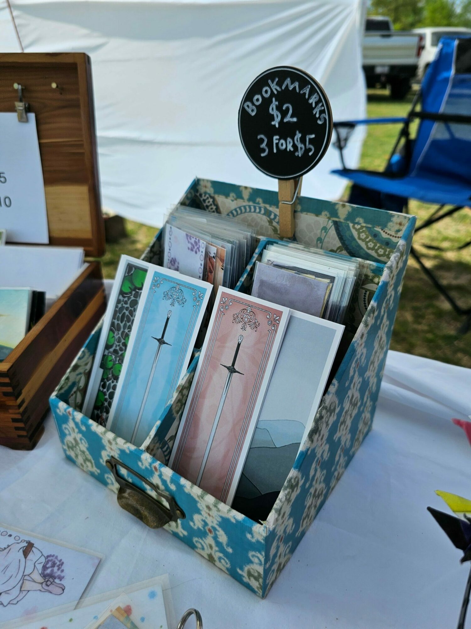 Display box with religious postcards and a sign indicating 8 for $2, 3 for $1, on a table.