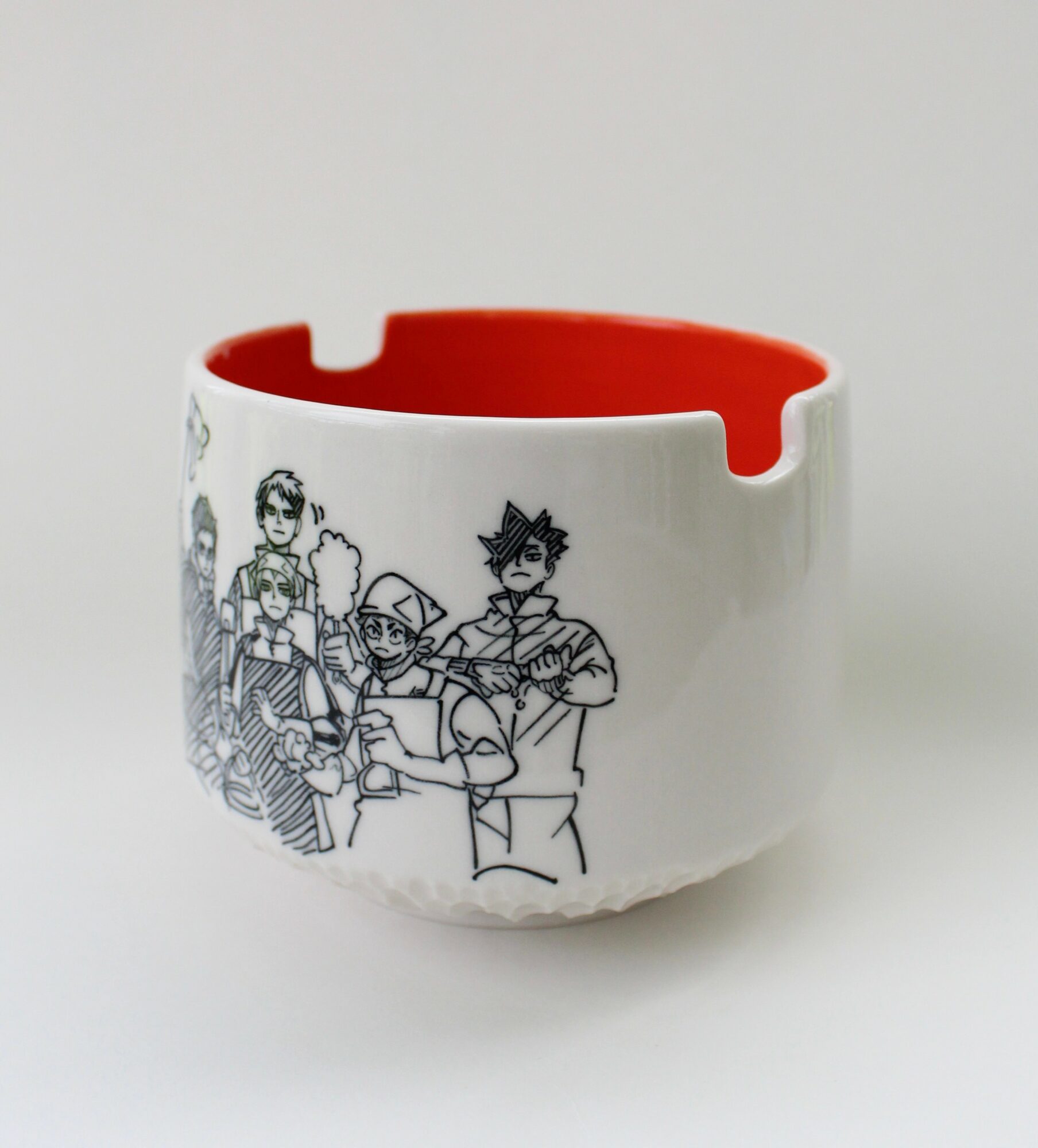 White bracelet with black line drawing of multiple characters, red interior, and a cutout section, on a white background.