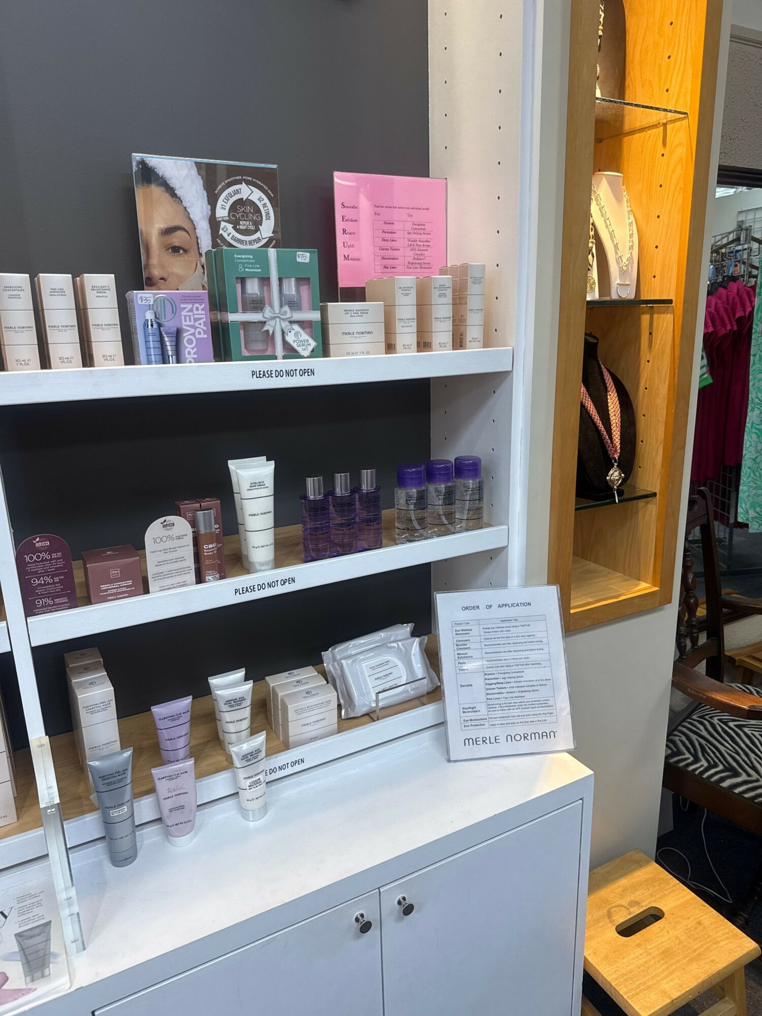 Display of skincare or cosmetic products on a shelf with labels and packaging, some in tubes and bottles.