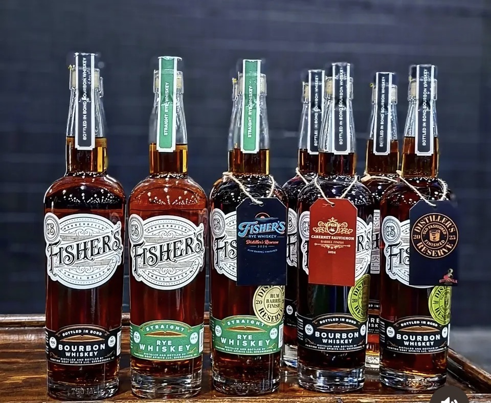 Six bottles of whiskey and bourbon arranged in a row on a surface, with labels visible.