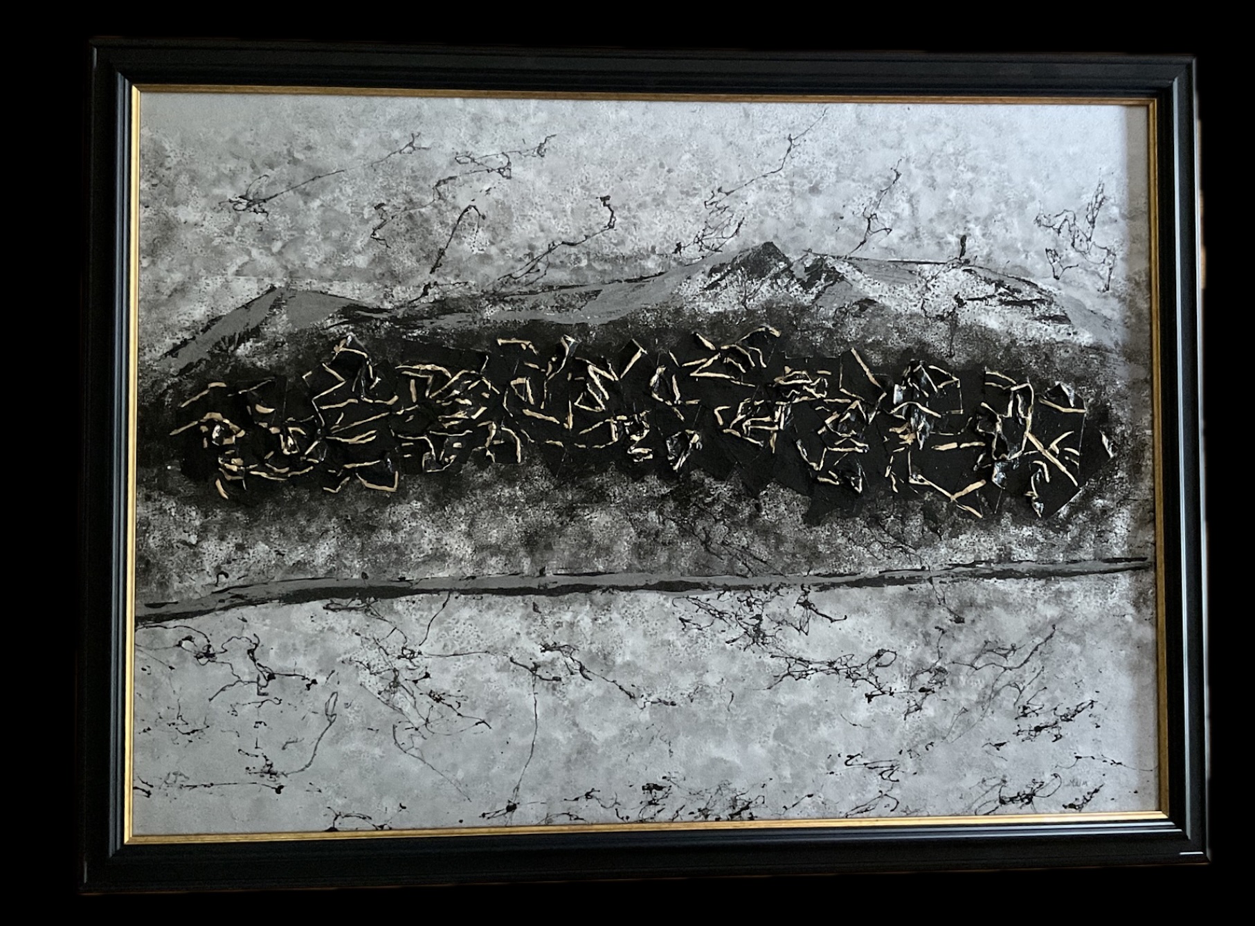 A framed artwork features a textured gray background with a dark, irregularly shaped central element resembling a snake or ribbon.