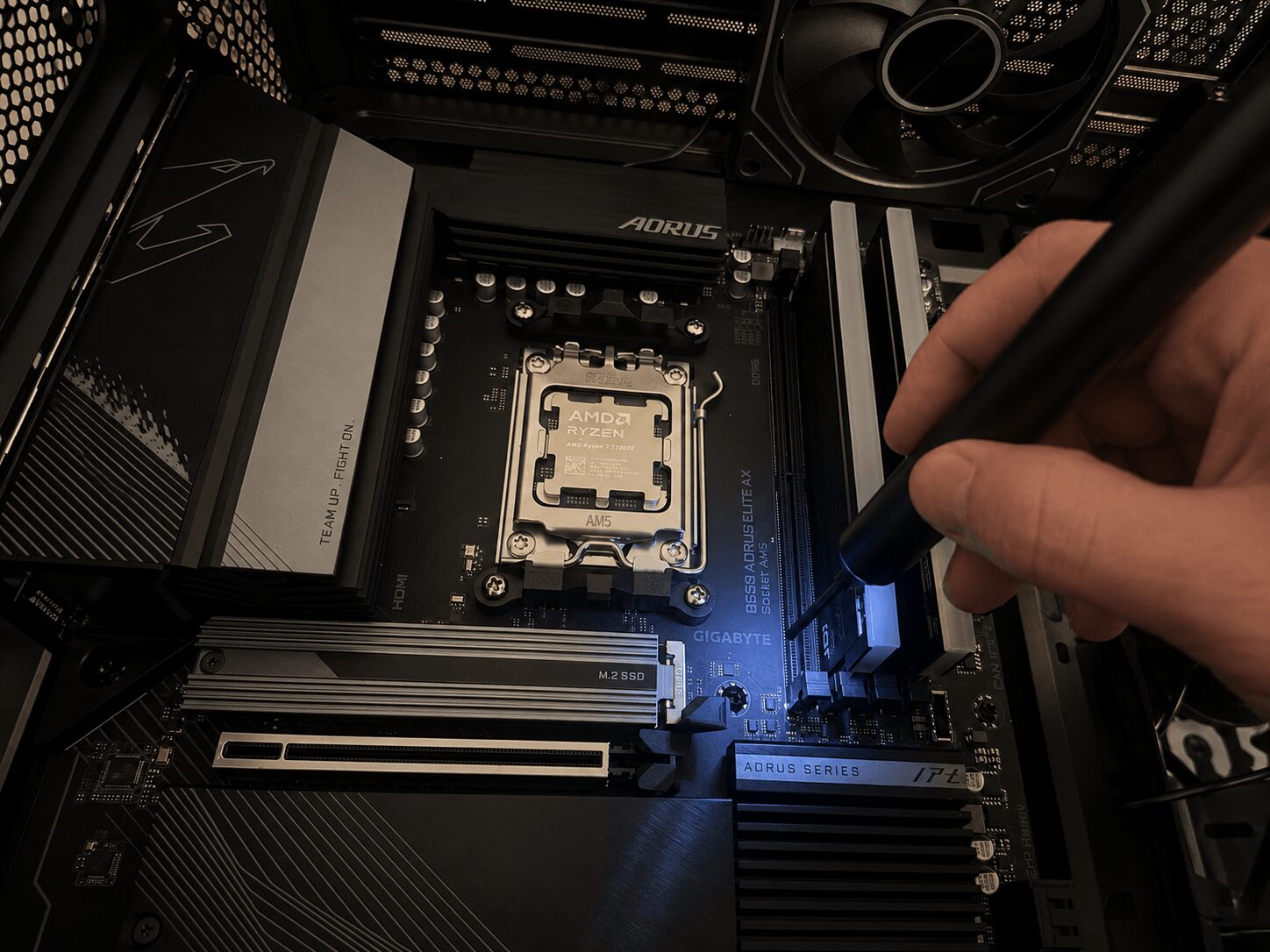 Person using a black tool to install a CPU into a computer motherboard inside a case, with various components visible.