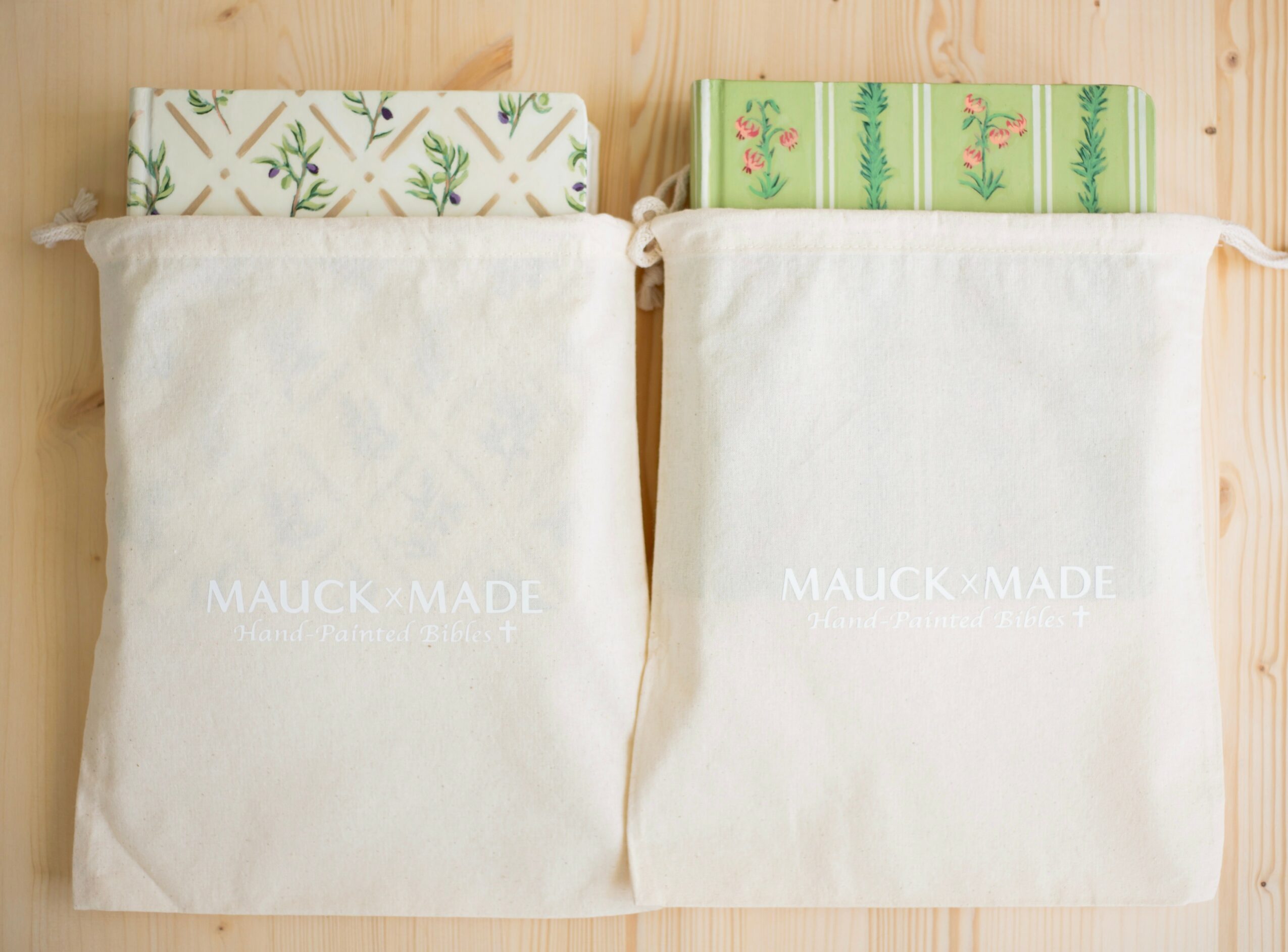 Two fabric pouches with patterned book covers inside, placed on a wooden surface.
