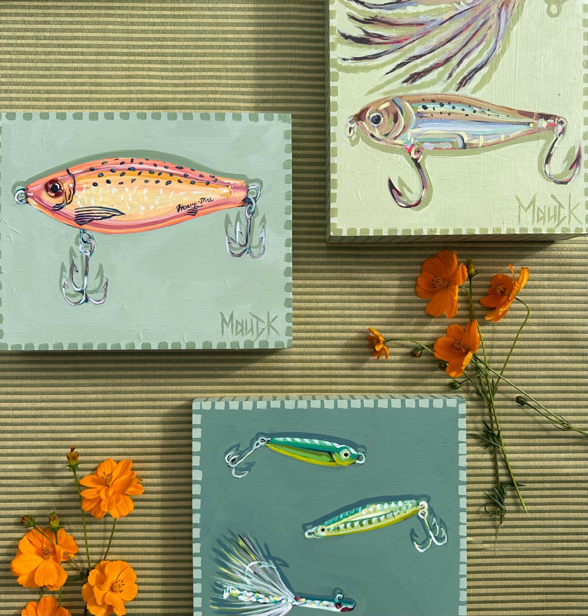 Three illustrated fish on paper, with orange flowers and green stems beside them, on a striped background.