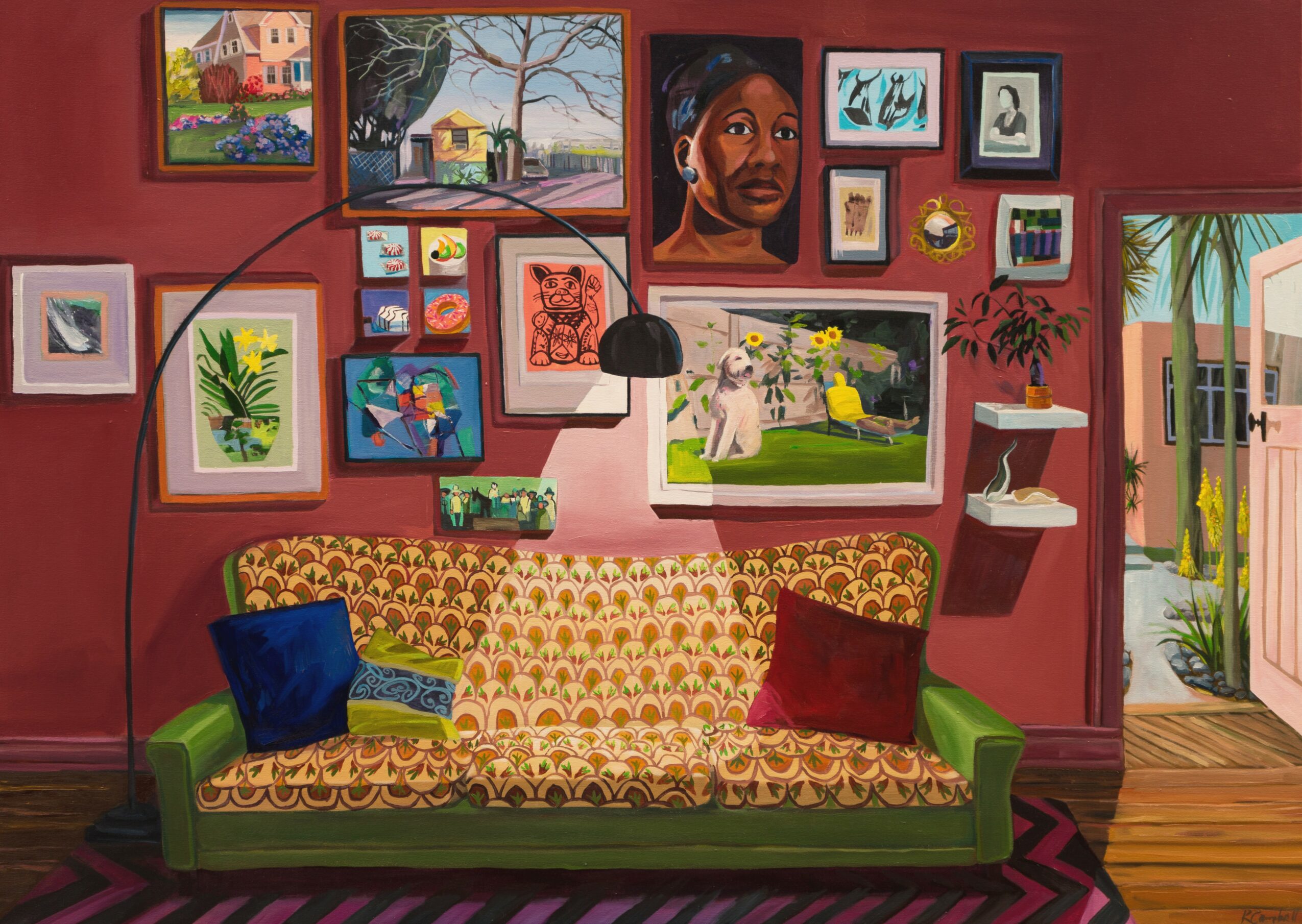 Living room with a patterned sofa, colorful pillows, and a gallery wall of various framed artworks and photos.