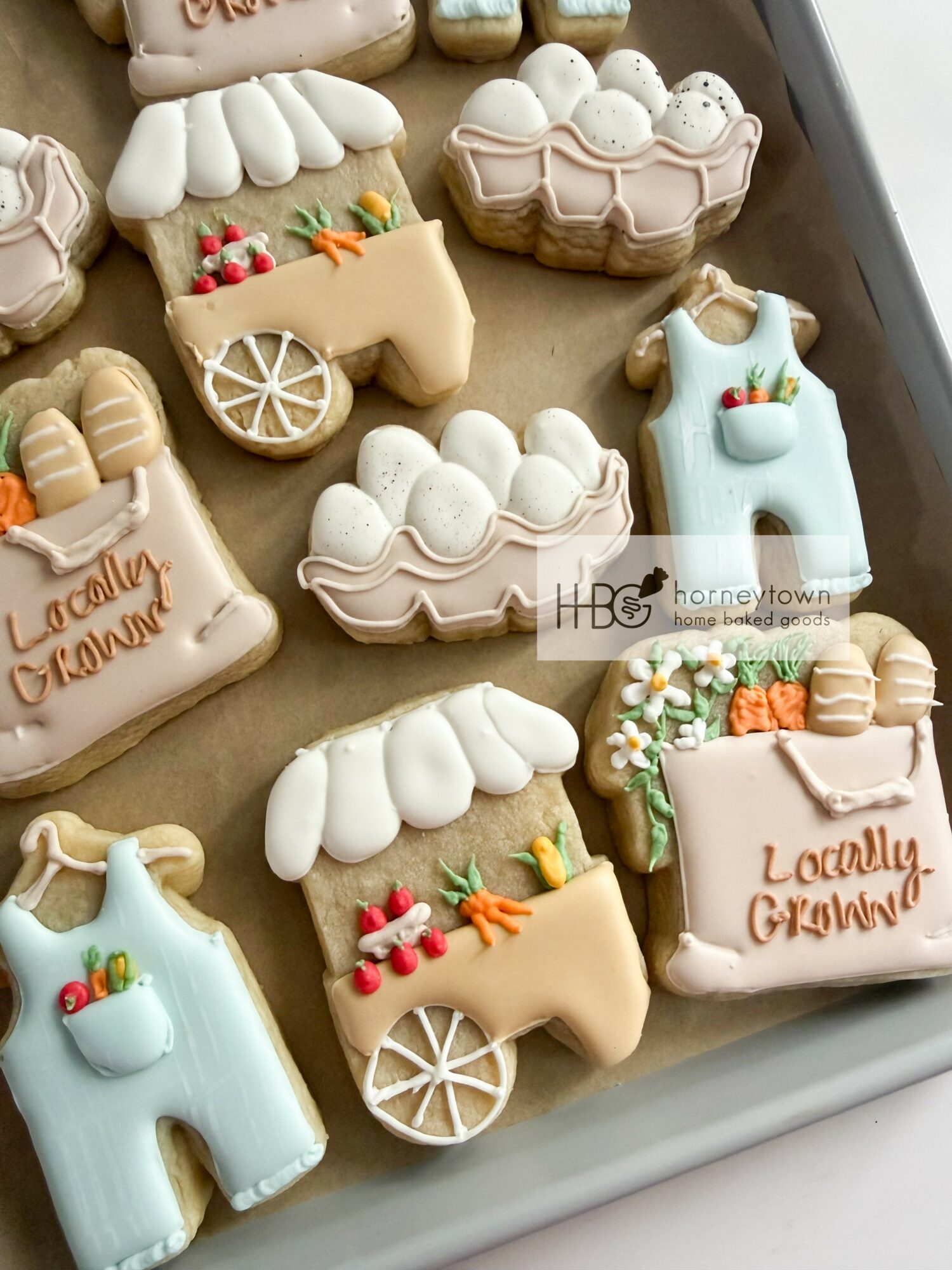 Assorted decorated cookies with holiday themes, including snowflakes, snowmen, and gift boxes, on a baking sheet.