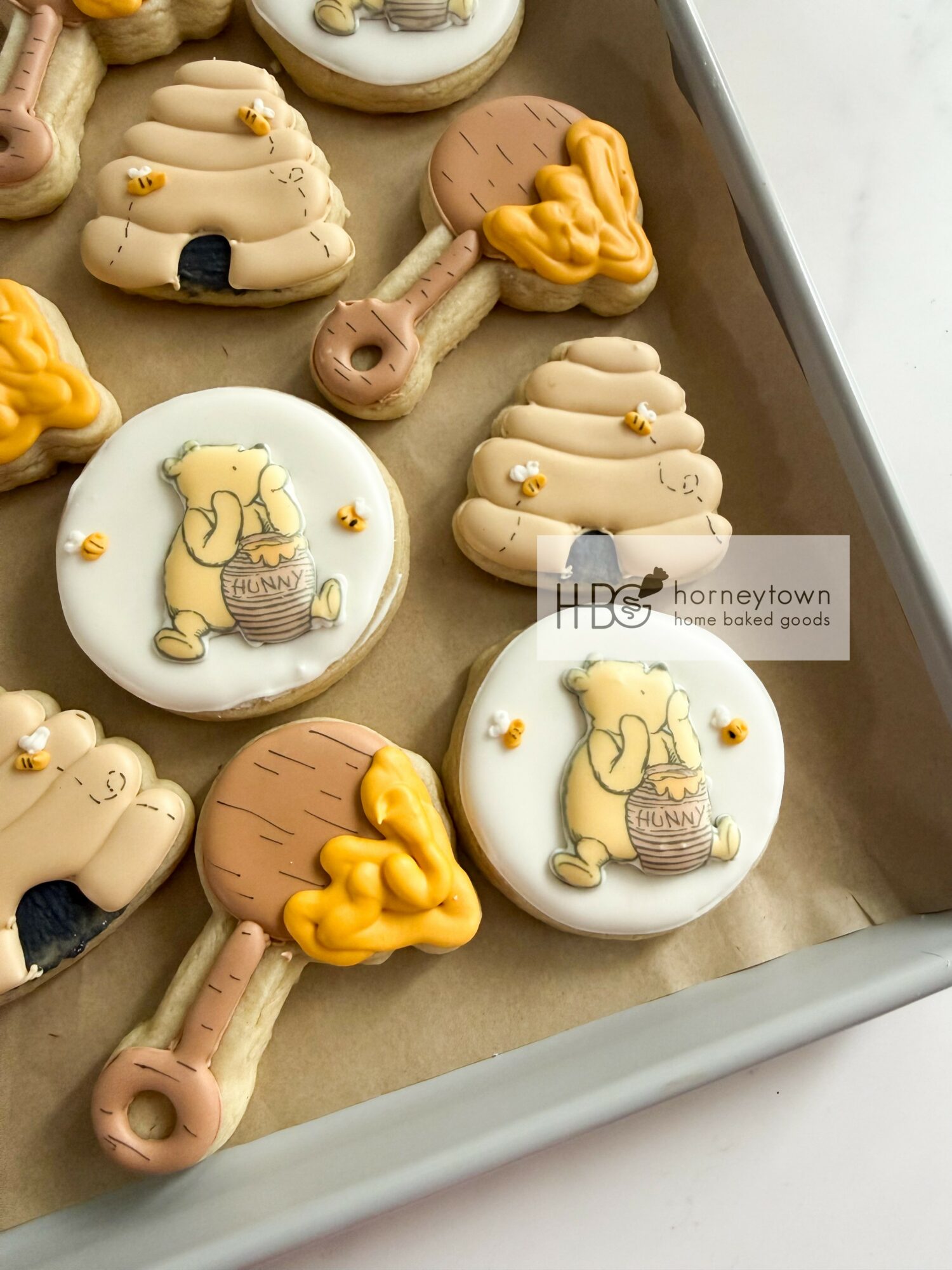 Assorted cookies with animal and heart shapes on a tray, decorated with icing and small edible details.