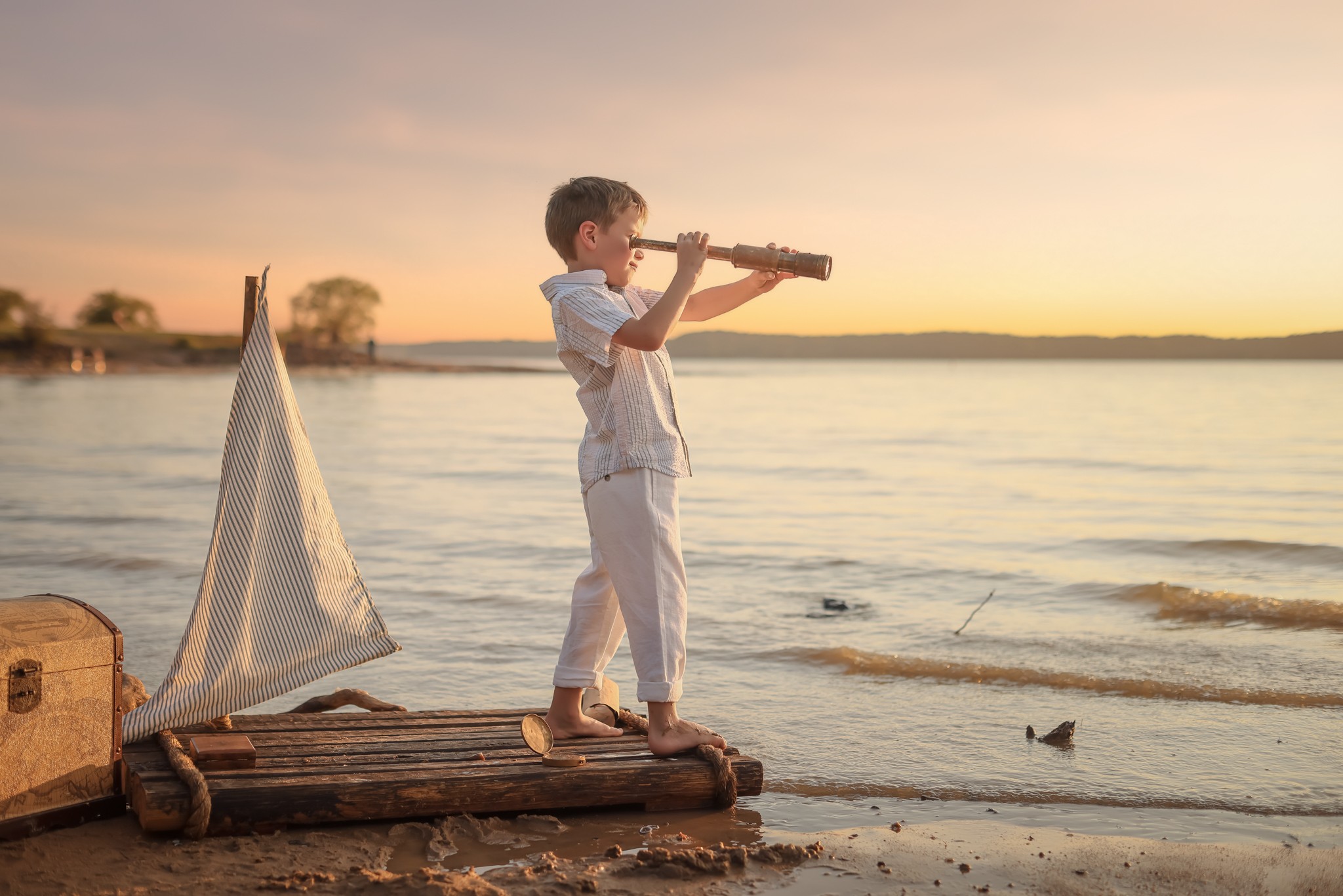 Child standing on a wooden dock by the water, playing a flute during sunset, with a sailboat nearby.