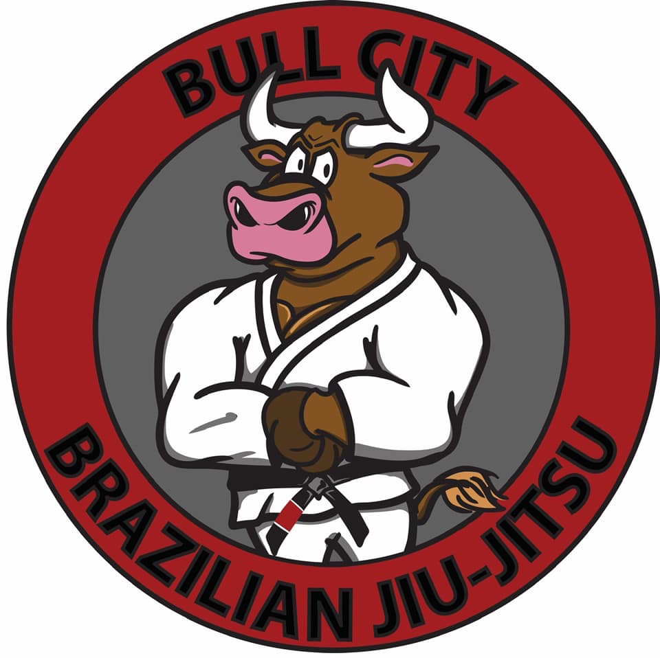 Logo with a cartoon bull in a martial arts uniform, arms crossed, inside a red circle with black text.