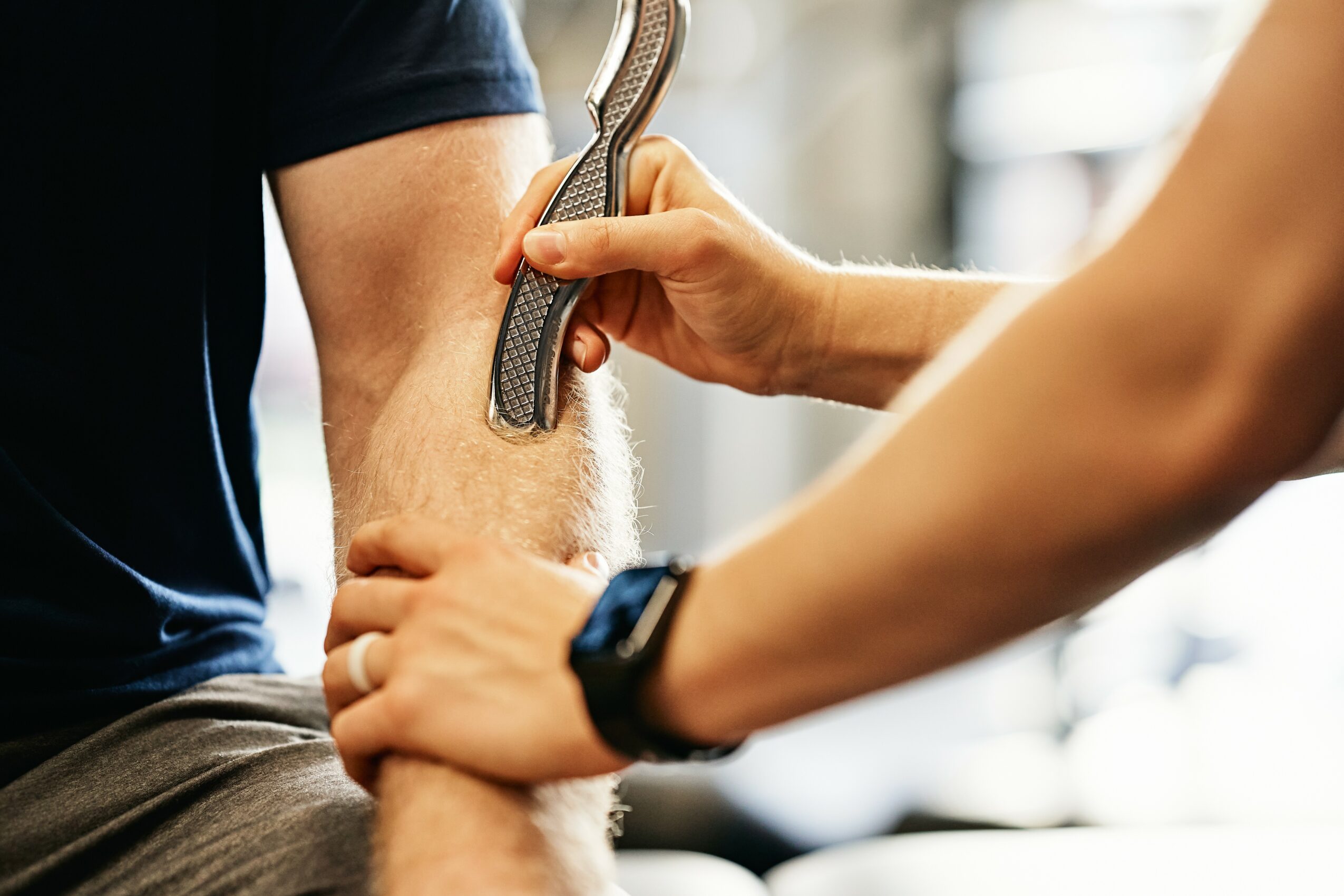 Person receiving a snake bite simulation on their arm from another person in a gym or training environment.