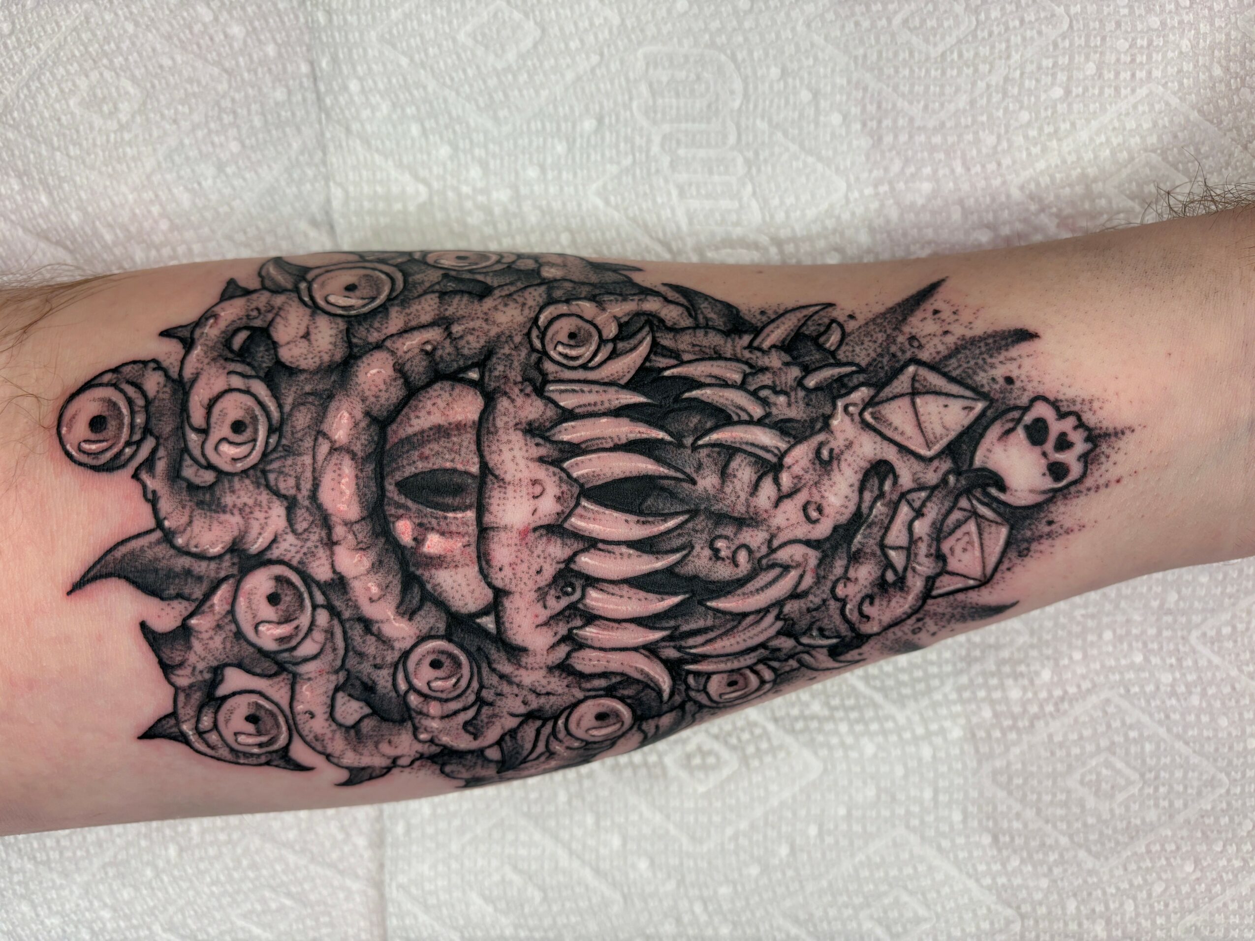 Detailed black and gray octopus tattoo on forearm with tentacles and shading.