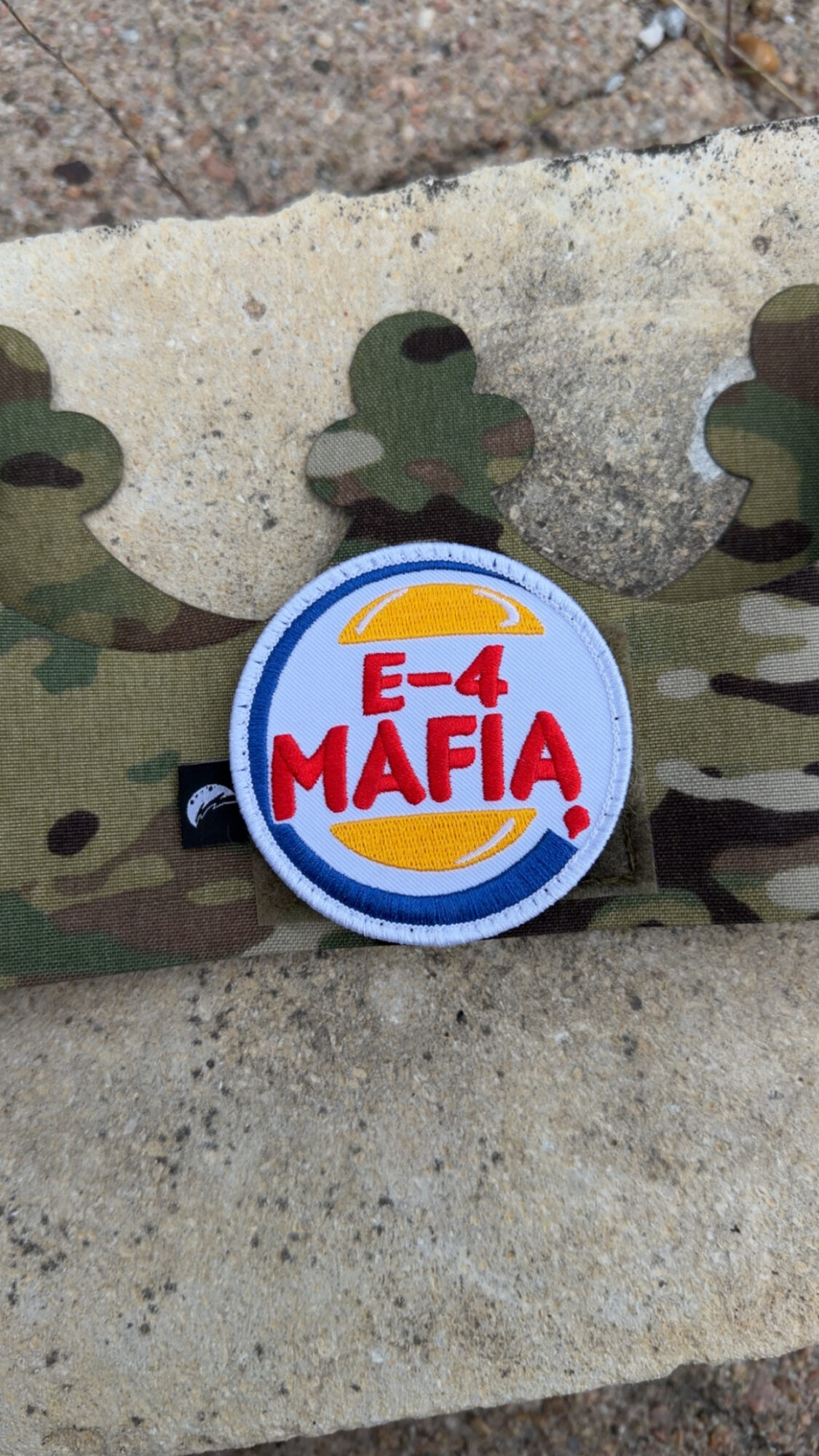 Circular badge with blue, yellow, and red design, reading