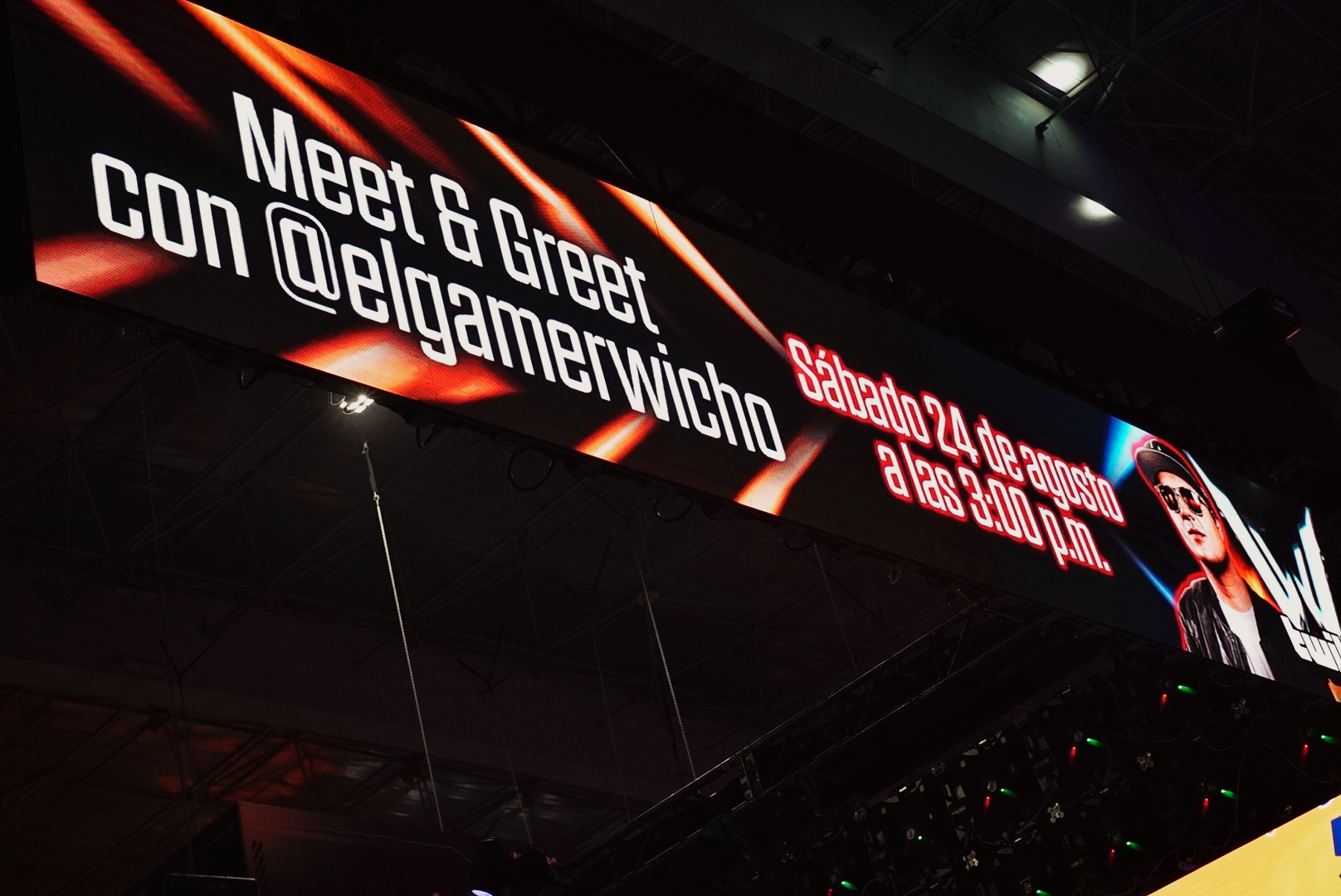 Digital sign advertising a meet and greet with a person, with text in Spanish and English, and a photo of a woman.